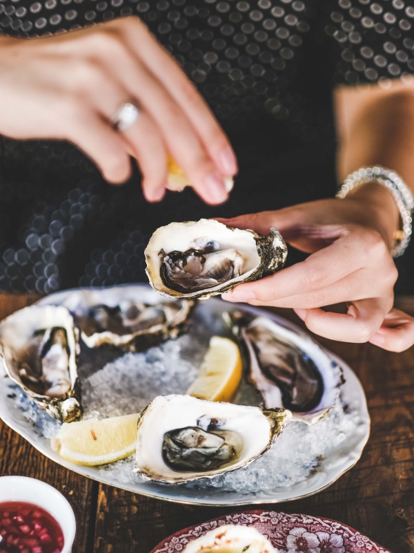 Woman Squeezing Lemon to Oyster