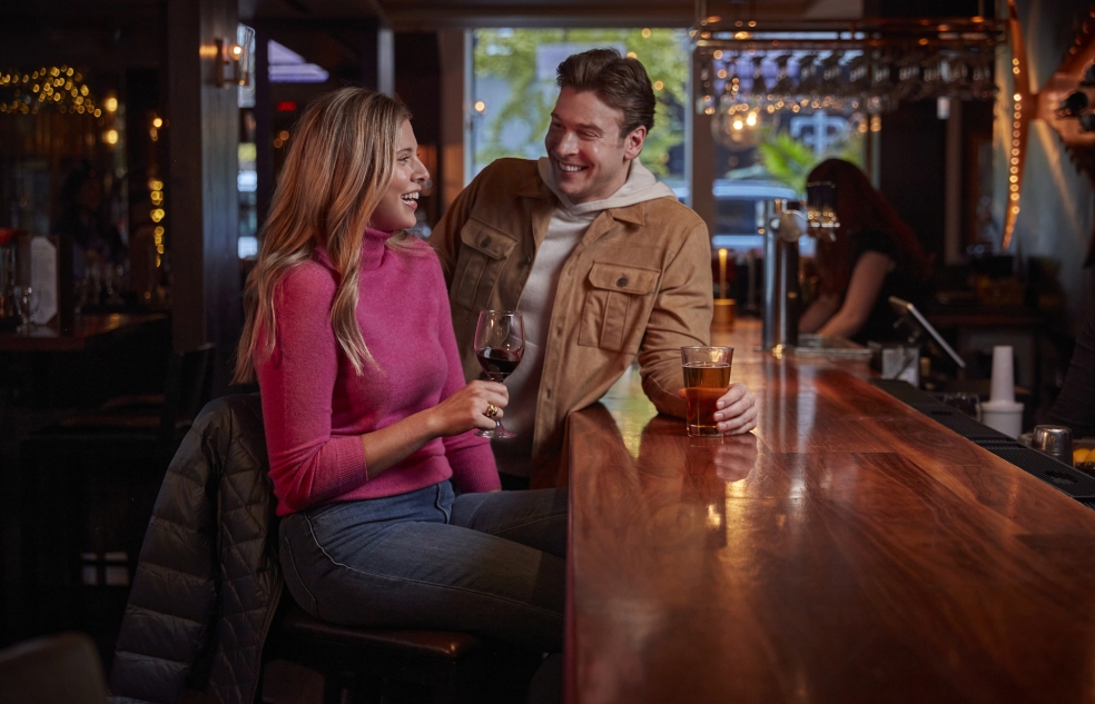 couple standing at bar with drinks